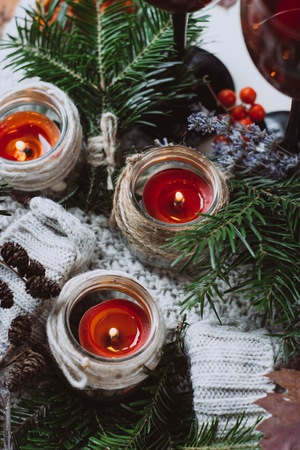 Autumn composition and candles and needles on a textured sweater on a wooden background. Autumn or Winter concept.の写真素材