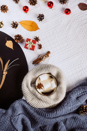 Autumn and Winter composition. Hot coffee with marshmallows, scarf, cookies, bumps, hat and autumn leaves. Flat lay, top viewの写真素材
