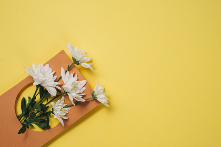 Creative layout made of white flowers on yellow background. Flat lay, top view, copy space. Nature minimal conceptの写真素材