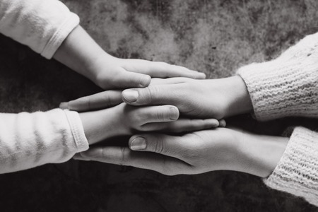 Close up view of family holding hands, loving caring mother supporting child. Helping hand and hope...