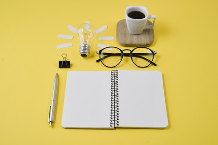 Top view flat lay of workspace desk styled design office supplies with pen, notepad, eyeglasses, cup...