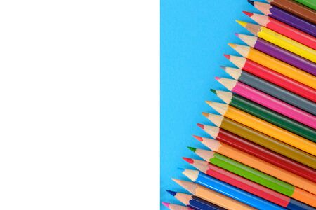 Creative flat lay back to school concept with colored pencils on blue and white background. Minimal concept art. Top view, copy space.の写真素材