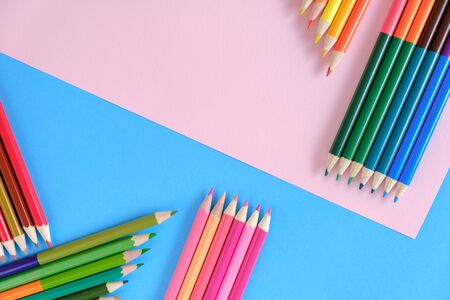 Creative flat lay back to school concept with colored pencils on blue and pink background. Minimal concept art. Top view, copy space.の写真素材