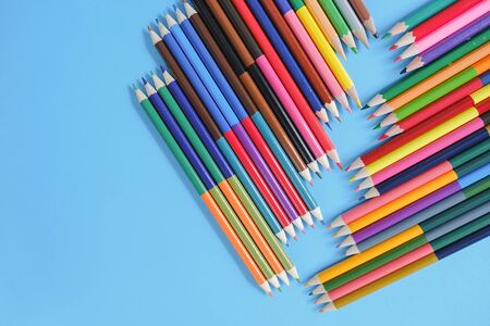 School concept. Closeup images of many color pencils on blue background. Flat lay, top view, copy...