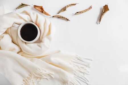 Autumn composition. Cup of coffee, scarf and dried leaves on gray background. Flat lay, top view, copy spaceの写真素材