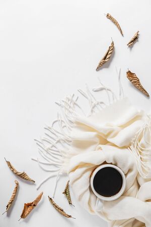 Autumn, fall concept. Cup of coffee, scarf and dried leaves on gray background. Autumn composition. Flat lay, top view, copy spaceの写真素材