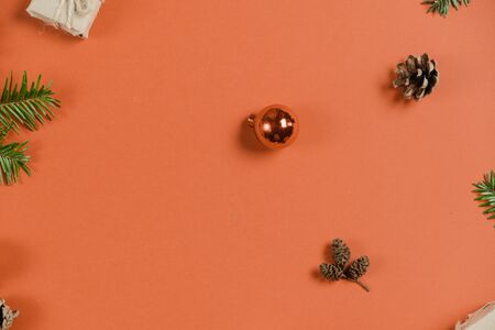 Christmas holiday composition. Handmade gift boxes decorated with craft paper of fir tree branches, pine on pastel orange background. Flat lay, top view, copy spaceの写真素材