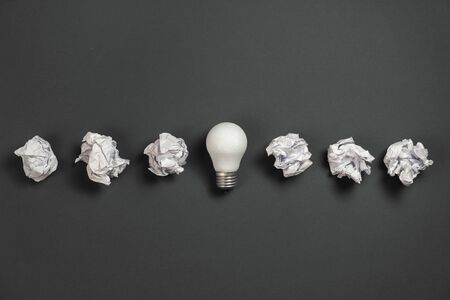 new idea concept with crumpled office paper and white light bulb on grey background. Creative...