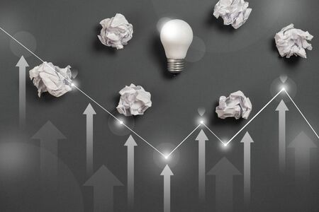 new idea concept with crumpled office paper, white light bulb and network connection on virtual...