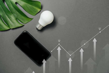 Creativity inspiration, ideas concepts with light bulb, digital diagram, graph interfaces, green leaf monstera and modern smartphone with copy space on gray background minimal style.の写真素材