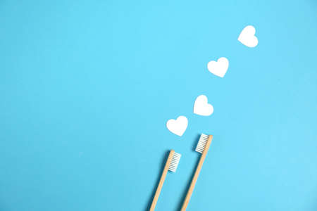 Zero waste concept. Two wooden bamboo eco friendly toothbrushes, white hearts on blue background....