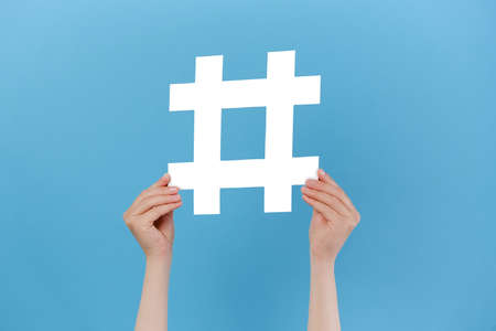 Horizontal images of female hands holding large big white hashtag sign, viral web content, internet...