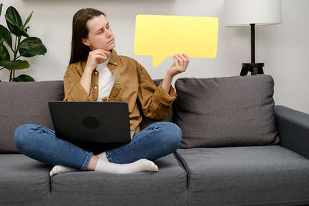Portrait of confused young caucasian female 20s old years entrepreneur with laptop computer, sitting...