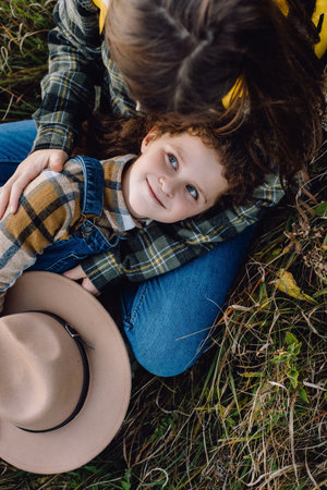 Top view close up of loving young mother hugging happy cute little daughter lying in old grass at...