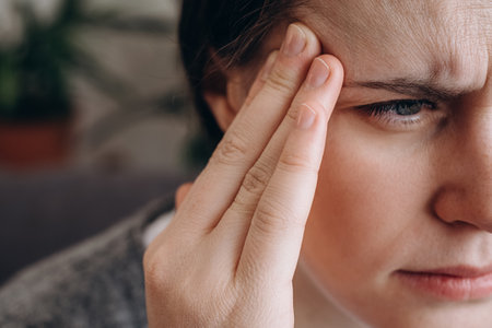 Close up of frustrated upset young brunette woman 20s coping with headache migraine concept feel...