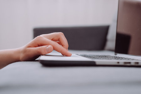 Close up of unknown young caucasian woman using laptop, female hands typing, writing notes, studying languages, distance learning concept, checking email in morning, working at homeの写真素材