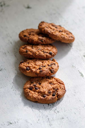 Fresh oatmeal cookies with chocolate on white table