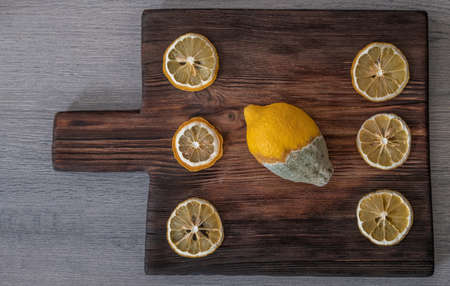 rotten lemon on a wooden boardの写真素材