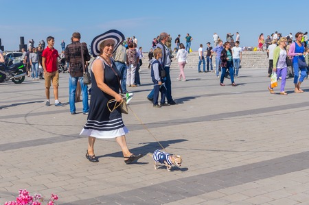 DNEPROPETROVSK, UKRAINE - SEPTEMBER 12, 2015: Cute pair - woman with her small dog on the Dnepr river embankment during City Day local activity, September 12, 2015, Dnepropetrovsk, Ukraineのeditorial素材