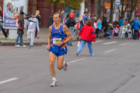 DNEPR, UKRAINE - SEPTEMBER 25, 2016:Senior participant hurrying to finish line during "Dnepr Eco Marathon" race on the city street at September 25, 2016 in Dnepr, Ukraineのeditorial素材