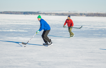 Dnipro, Ukraine - January 22, 2017: Two mature man fighting for the pack while playing hockey on a frozen river Dnepr in Ukraineのeditorial素材