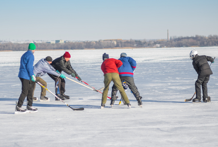 Dnipro, Ukraine - January 22, 2017: Group of different ages ordinary people playing hockey on a frozen river Dnipro in Ukraineのeditorial素材