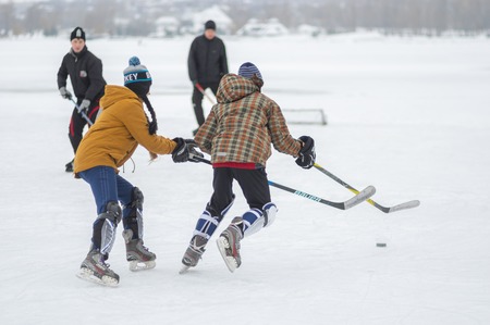 Dnipro, Ukraine - January 28, 2018: Teenager girl fighting with teenager boy  while playing hockey on a frozen river Dnipro in Ukraineのeditorial素材