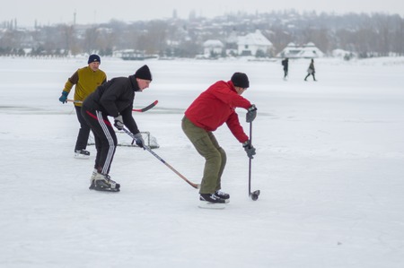 Dnipro, Ukraine - January 28, 2018: Group of different aged people playing hokey on a frozen river Dnipro in Ukraineのeditorial素材