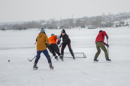 Dnipro, Ukraine - January 28, 2018: Group of different aged people playing hokey on a frozen river Dnipro in Ukraineのeditorial素材