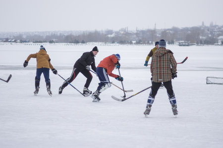 Dnipro, Ukraine - January 28, 2018: Group of active different age and sex people playing hokey on a frozen river Dnipro in Ukraineのeditorial素材