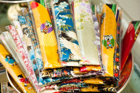 Wooden hand-made fans are wrapped in the asian colourful fabric covers の写真素材