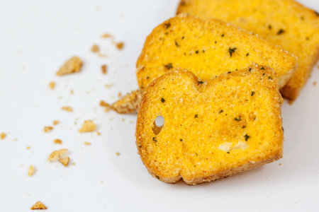 garlic bread with crumbs on white backgroundの写真素材