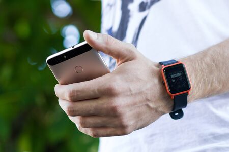 Man using smartphone and smart watch.
