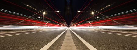 Blurred lights of vehicles. Night traffic. Bridge road at night.
