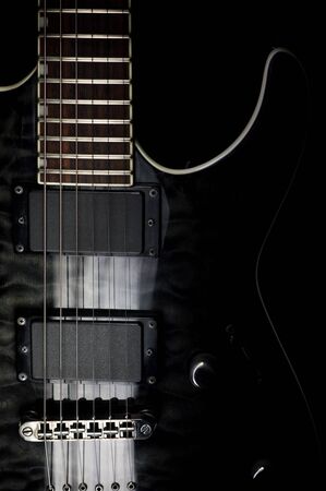 Body of a modern electric black guitar. Close-up photo with light painting technique.の写真素材