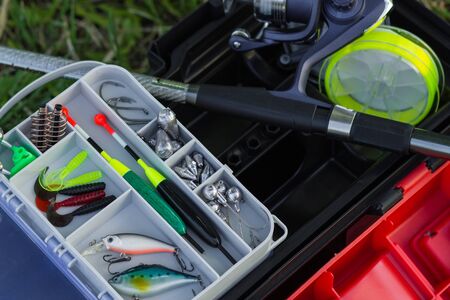 Modern fishing gear. Top view on fishing reel, fishing rod, fishing float, fishing line and fishing weights in box.の写真素材