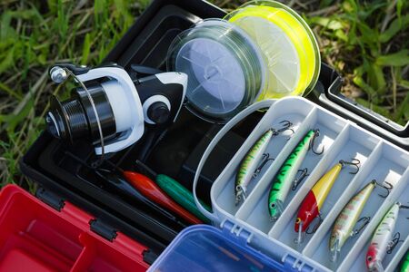 Spinning reel, fishing line, plastic tackles, artificial lures and other hobby fishing gear. Outdoor hooby and leisure concept. の写真素材