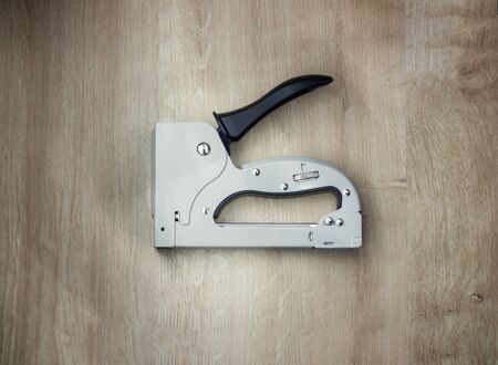 The furniture stapler on wood background close-up.の写真素材