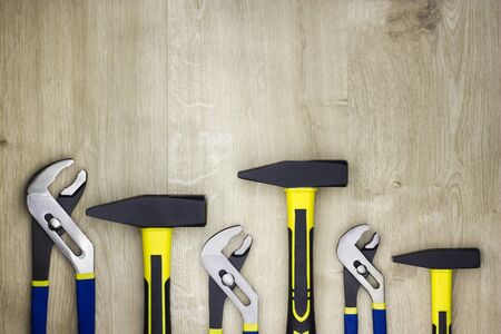 Set of tools on a wooden table. Hammers and wrenches. Plumber tools.