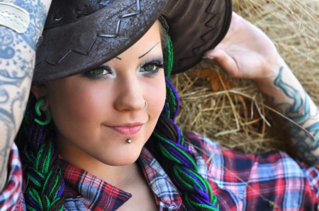 young tattooed  stylish woman with dreadlocks in cowgirl styleの写真素材