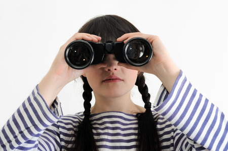 young female sailor looking through binoculars on white backgroundの写真素材