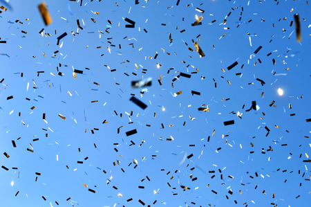 falling confetti in the city festival on blue sky backgroundの写真素材