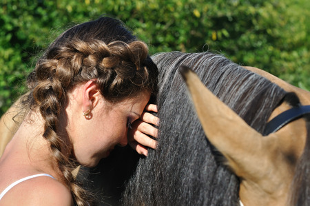 Conceptual portrait of young attractive woman with the horse in sunny dayの写真素材