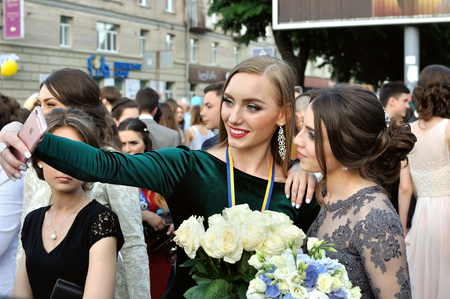 Graduates from different schools taking selfie in a celebration parade in the street  on May 28, 2016 in Cherkasy, Ukraineのeditorial素材