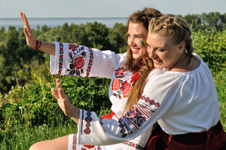 outdoor portrait of two young ukrainian women in traditional ukrainian clothesの写真素材