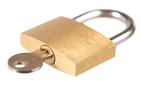 Closed yellow padlock with a key on whiteの写真素材
