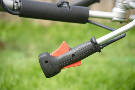 Gas handle for a gas trimmer on a green background close-up