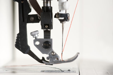 A sewing machine with a needle with red thread