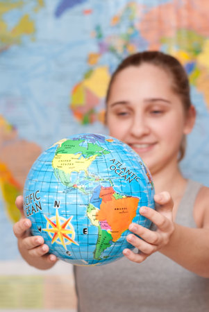 A smiling student girl with a globeの写真素材