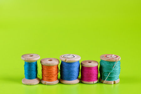 Old wooden rails of thread on green background